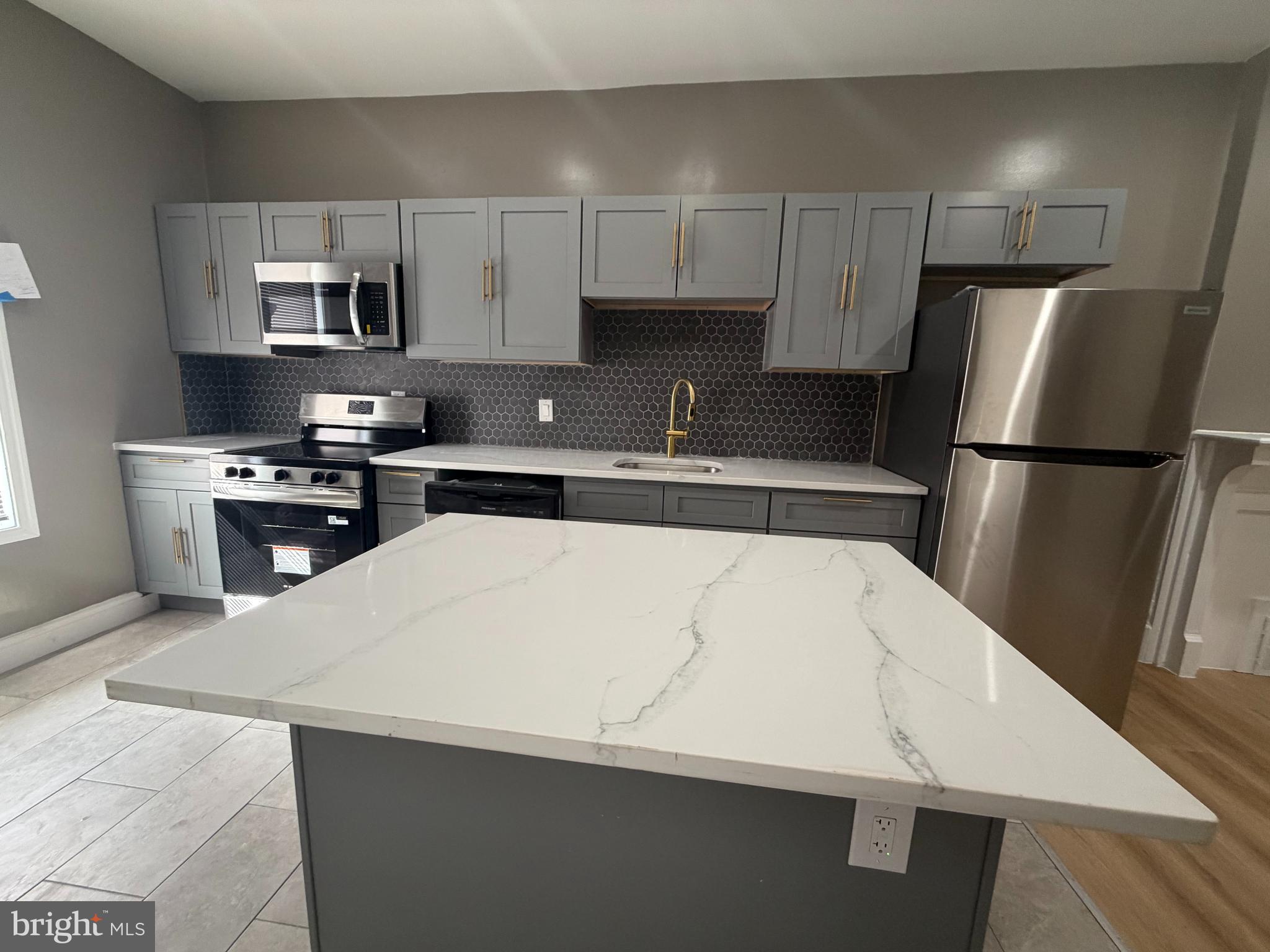 2260 North 18th Street Philadelphia, PA 19132 - Photo 7 of 13 a kitchen with cabinets and stainless steel appliances