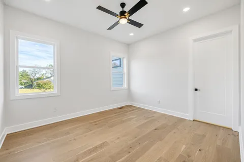 an empty room with a window and a ceiling fan