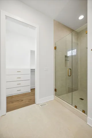 a bathroom with a shower and a glass door