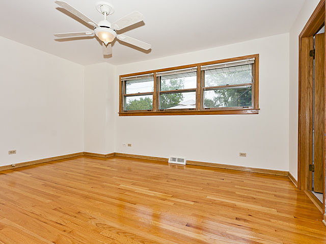 869 Spring Road Elmhurst, IL 60126 - Photo 7 of 25 a view of an empty room with wooden floor and a window