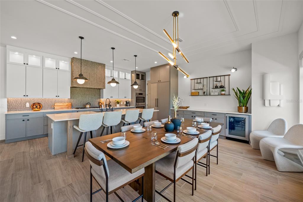 401 77th Street Holmes Beach, FL 34217 - Photo 14 of 92 a open dining room with stainless steel appliances kitchen island granite countertop a table chairs and a refrigerator