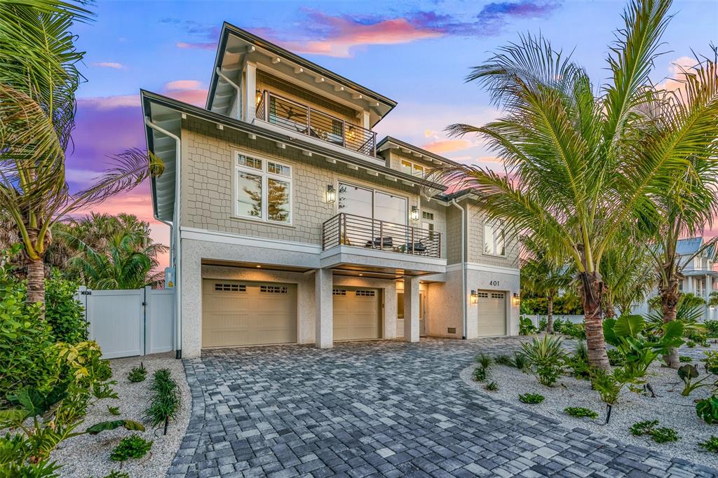 401 77th Street Holmes Beach, FL 34217 - Photo 2 of 92 a front view of a house with a garden