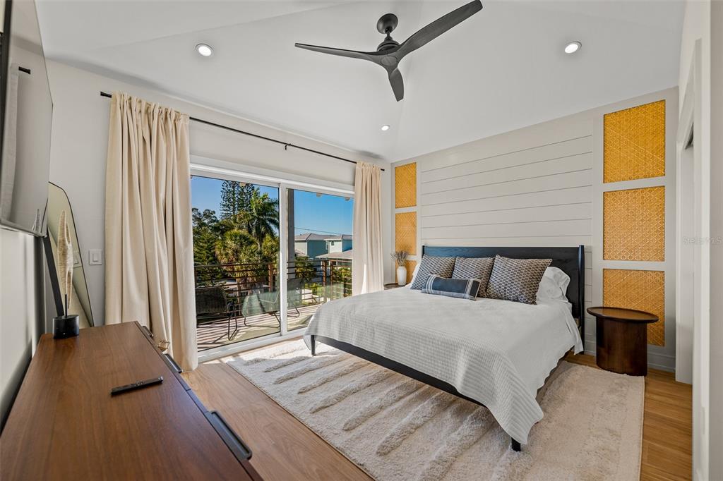 401 77th Street Holmes Beach, FL 34217 - Photo 31 of 92 a bedroom with a large bed and a chandelier