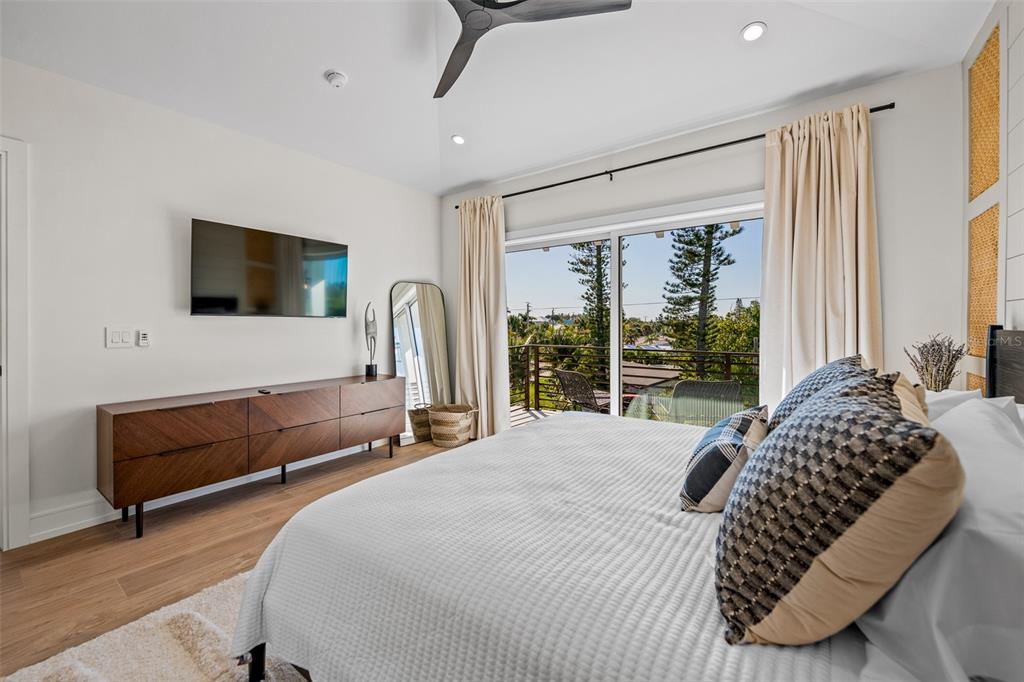 401 77th Street Holmes Beach, FL 34217 - Photo 32 of 92 a bedroom with a bed and a flat screen tv