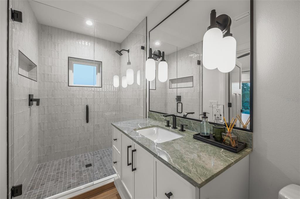 401 77th Street Holmes Beach, FL 34217 - Photo 41 of 92 a bathroom with a sink vanity granite and a mirror