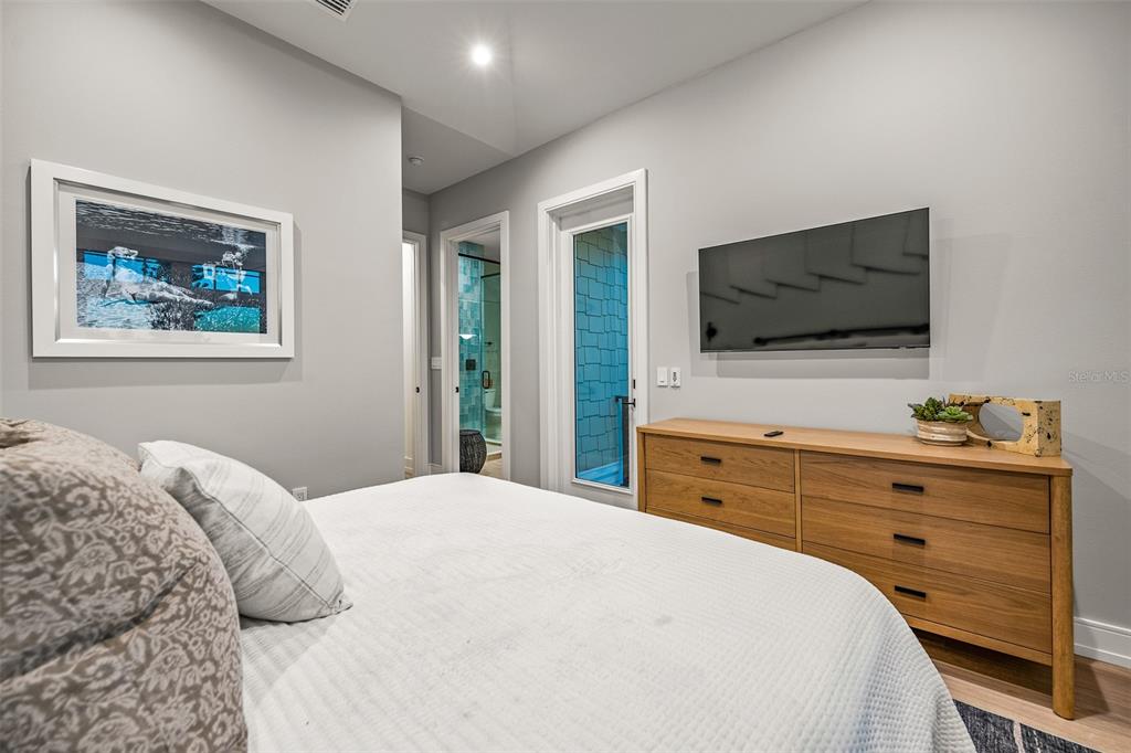 401 77th Street Holmes Beach, FL 34217 - Photo 43 of 92 a bedroom with a bed and a flat screen tv