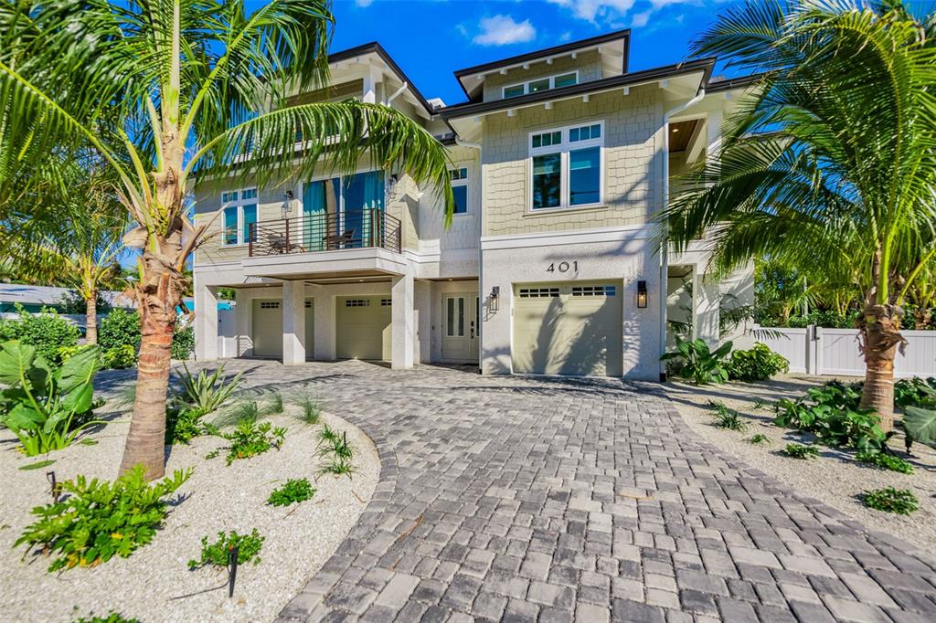 401 77th Street Holmes Beach, FL 34217 - Photo 5 of 92 a front view of a house with a garden