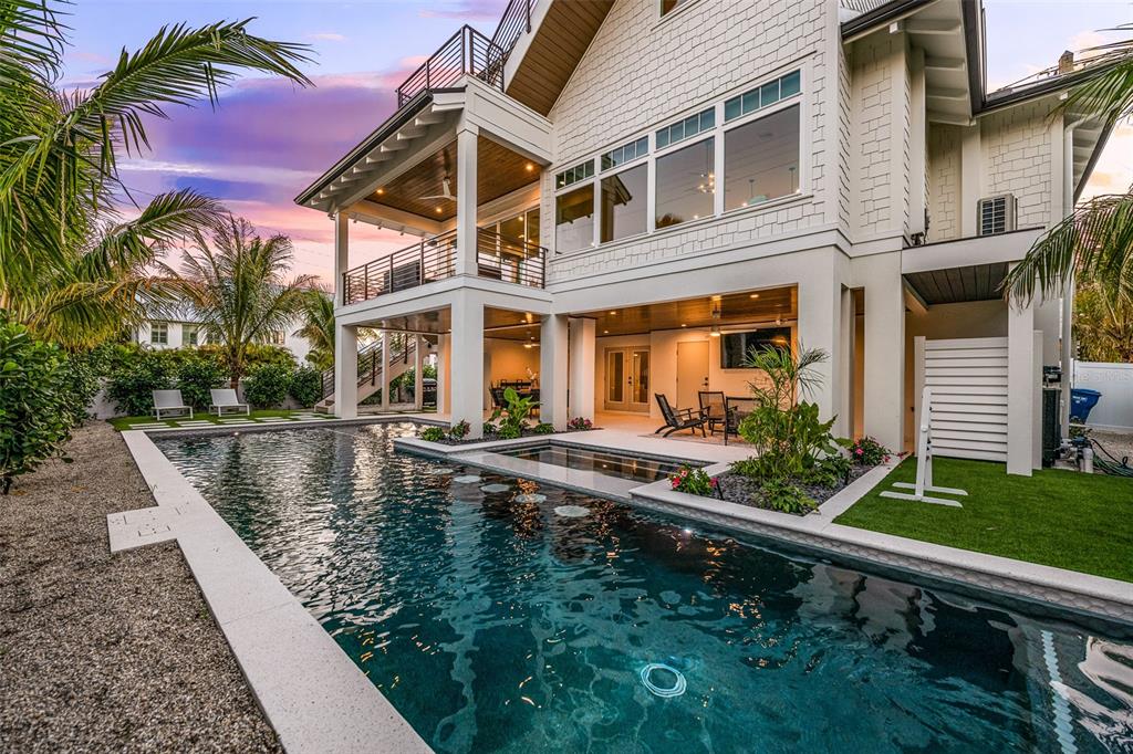 401 77th Street Holmes Beach, FL 34217 - Photo 54 of 92 a view of a house with pool plants and chairs