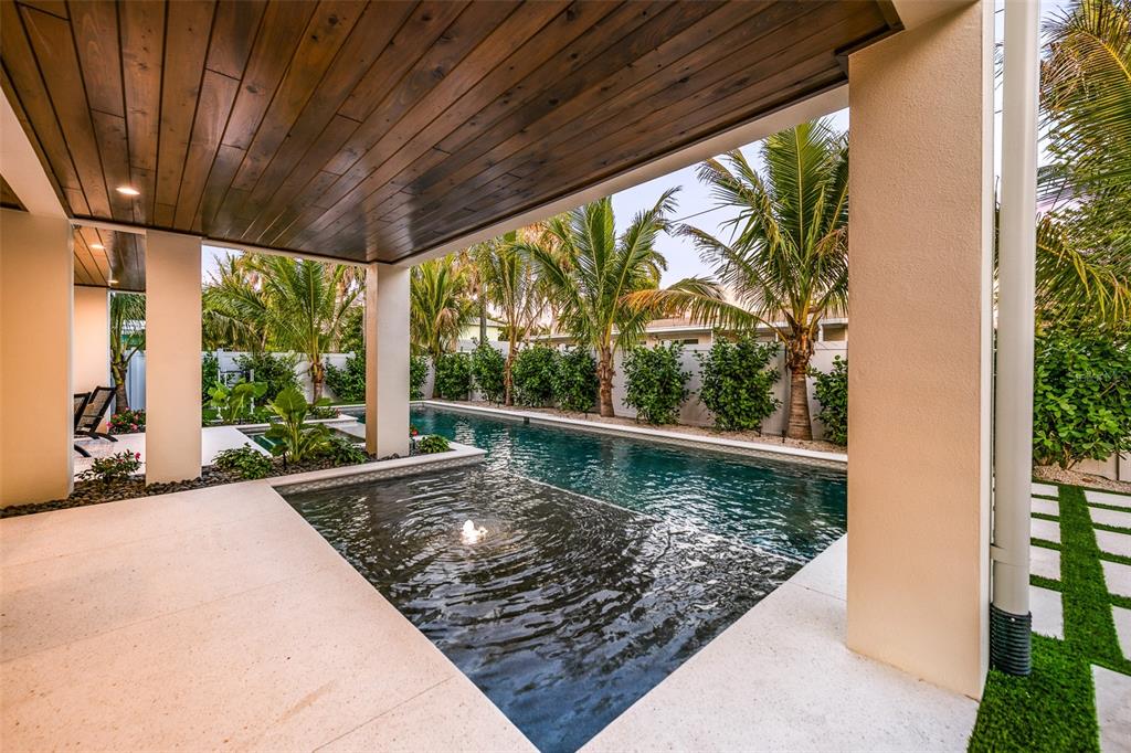 401 77th Street Holmes Beach, FL 34217 - Photo 59 of 92 a view of a porch with wooden floor and roof with a garden view