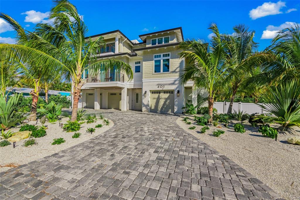 401 77th Street Holmes Beach, FL 34217 - Photo 77 of 92 a front view of a house with a yard and potted plants
