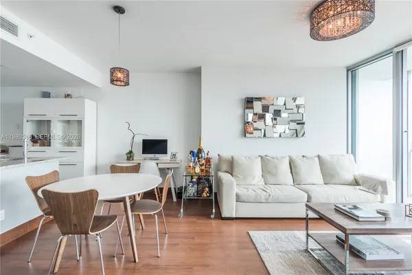 a living room with furniture a flat screen tv and a table