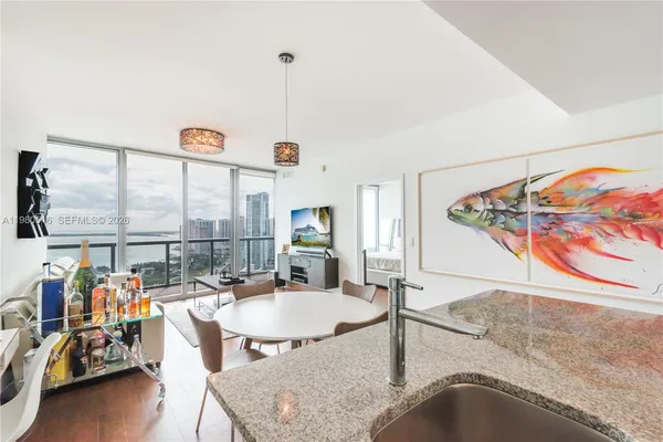 a dining room with furniture and a floor to ceiling window