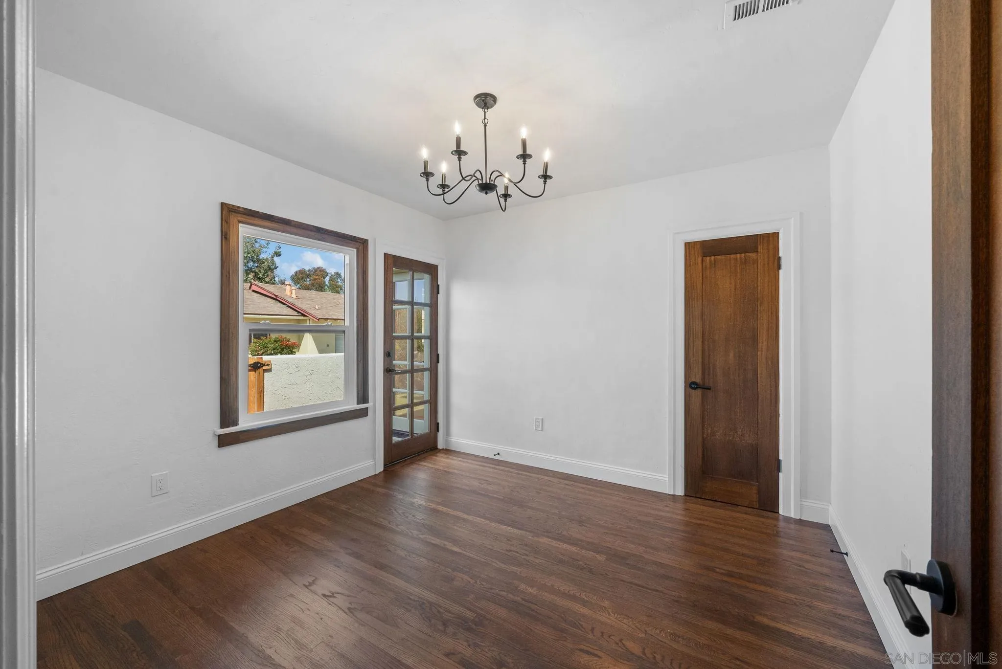4052 Alder Drive San Diego, CA 92116 - Photo 19 of 28 a view of an empty room with a window and wooden floor