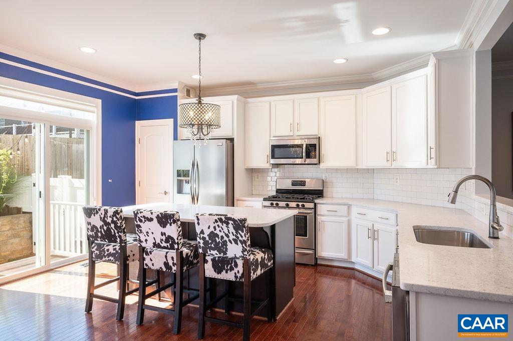 2146 Avinity Loop Charlottesville, VA 22902 - Photo 3 of 27 a kitchen with stainless steel appliances granite countertop a stove a sink a microwave a refrigerator and white cabinets with wooden floor