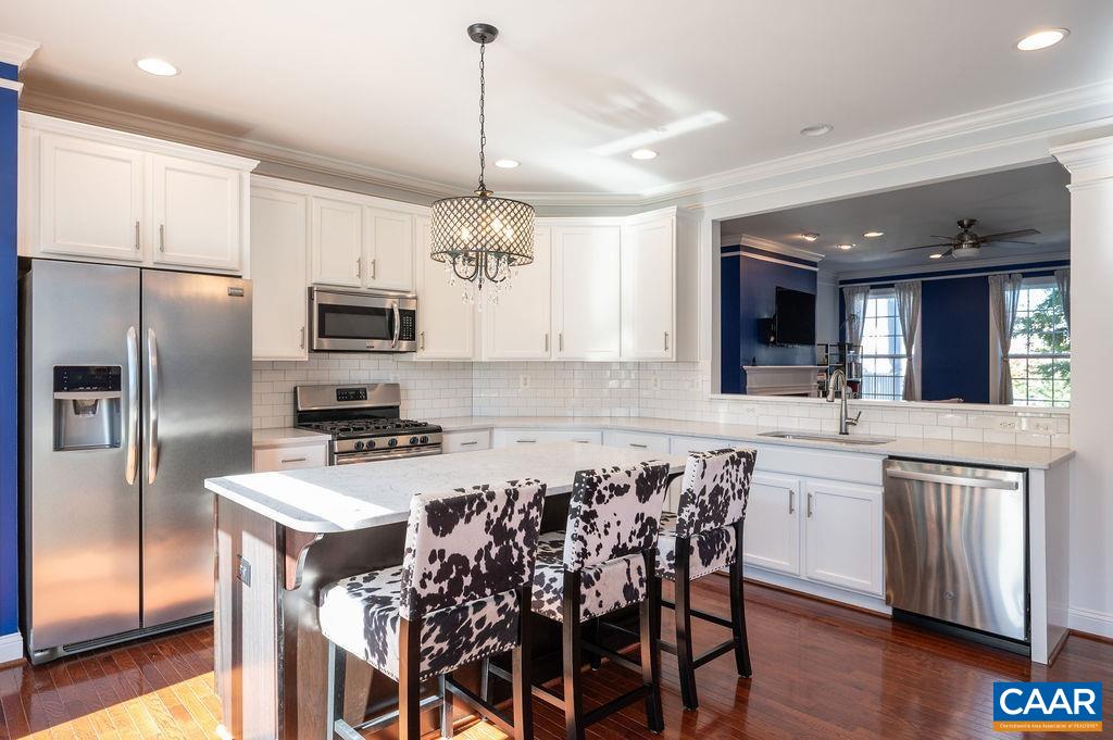 2146 Avinity Loop Charlottesville, VA 22902 - Photo 4 of 27 a kitchen with stainless steel appliances a sink a stove a refrigerator cabinets and a dining table