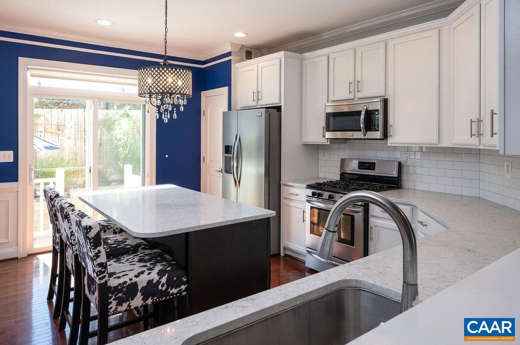 2146 Avinity Loop Charlottesville, VA 22902 - Photo 5 of 27 a kitchen with stainless steel appliances white cabinets a sink a stove a refrigerator and island