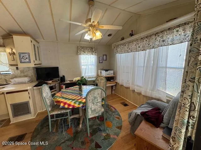 a view of a dining room with furniture a chandelier and window