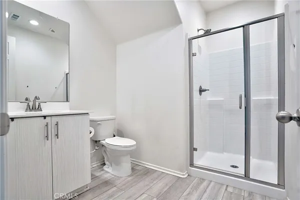 a kitchen with stainless steel appliances granite countertop a refrigerator a stove top oven a sink and dishwasher with wooden floor