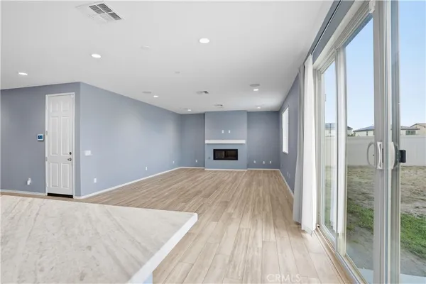 a view of empty room with a fireplace and wooden floor