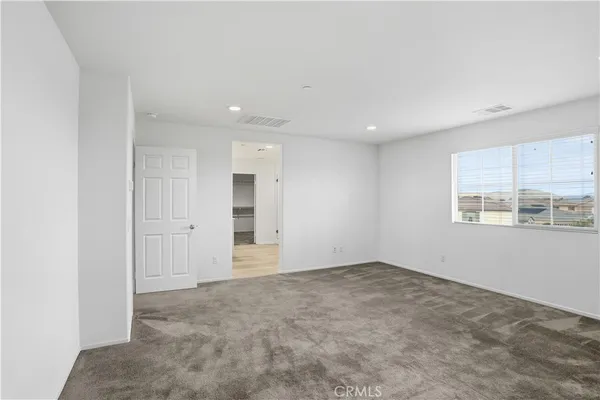 an empty room with windows and closet