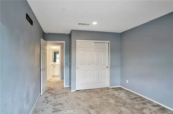 a view of an empty room with window and closet area