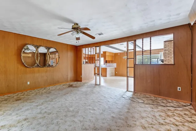 an empty room with windows and fan