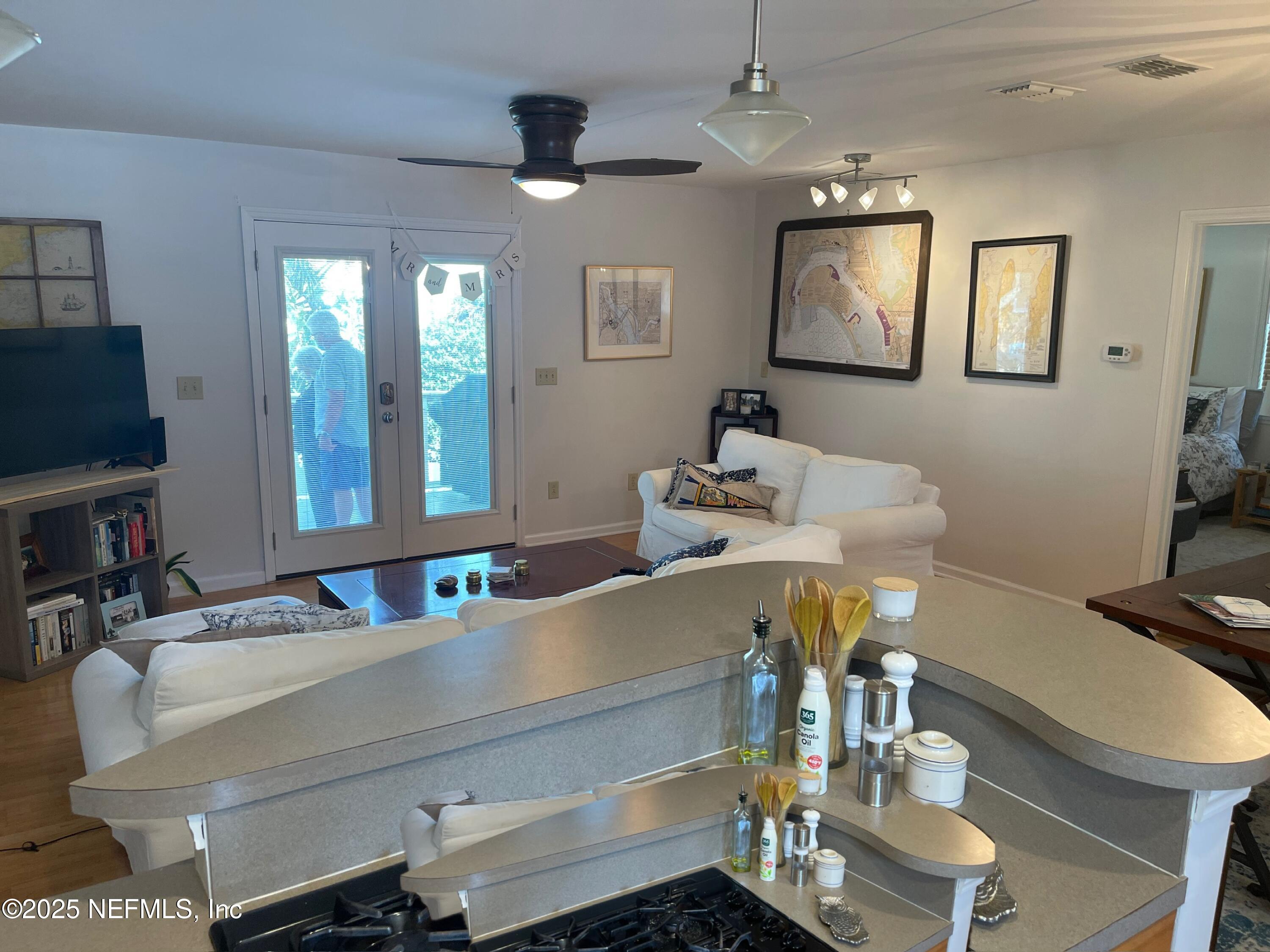 310 7th Street Atlantic Beach, FL 32233 - Photo 5 of 16 a dining room with wooden floor a chandelier a glass table and chairs