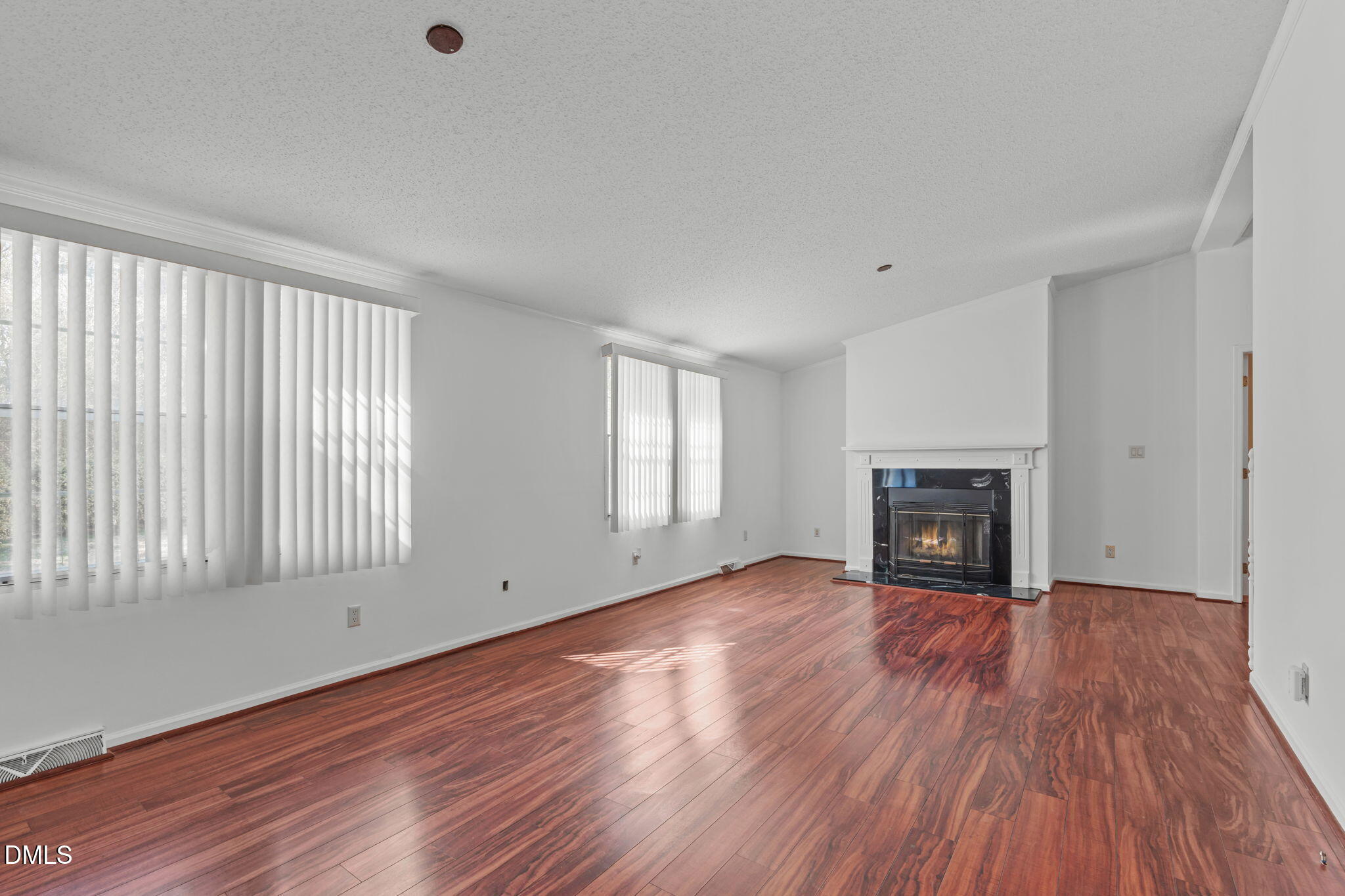 Gas log fireplace with niches for bookcases on either side, large windows for loads of natural light.