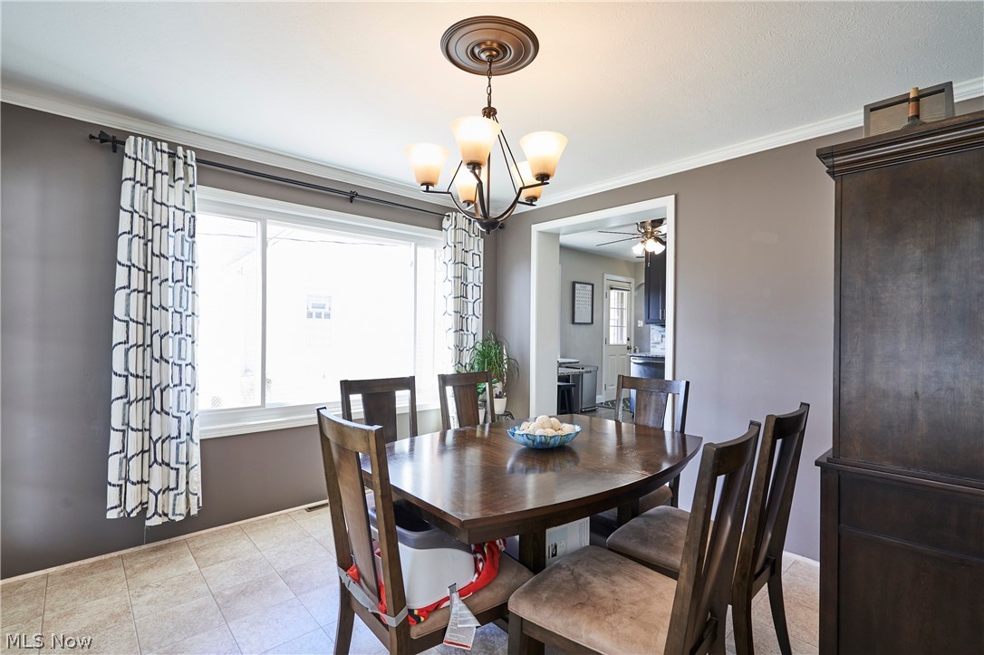 28322 Forest Road Willowick, OH 44095 - Photo 13 of 32 Dining area featuring light vinyl floors, ceiling fan with notable chandelier, and ornamental molding