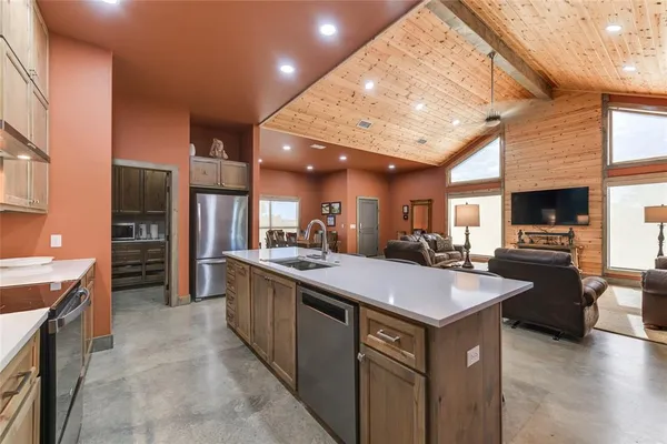 a large kitchen with kitchen island a sink counter space and stainless steel appliances