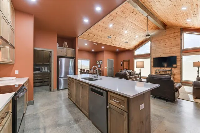 a large kitchen with kitchen island a sink counter space and stainless steel appliances