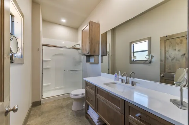 a bathroom with a sink a toilet and shower