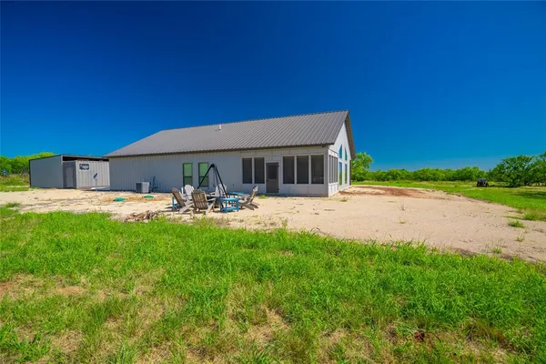 a view of swimming pool with outdoor seating and house in the background