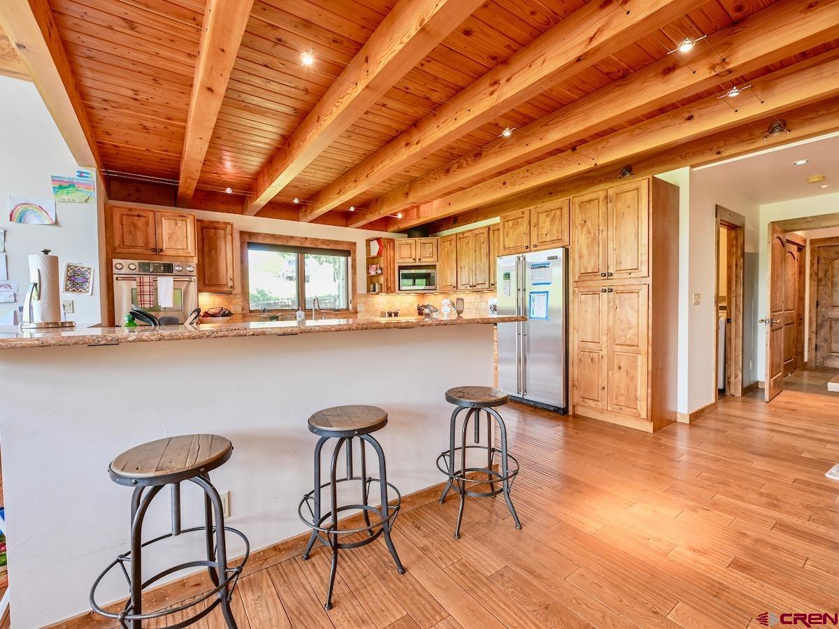930 Gothic Road Crested Butte, CO 81225 - Photo 11 of 35 a dining hall with stainless steel appliances granite countertop a table chairs and wooden floor
