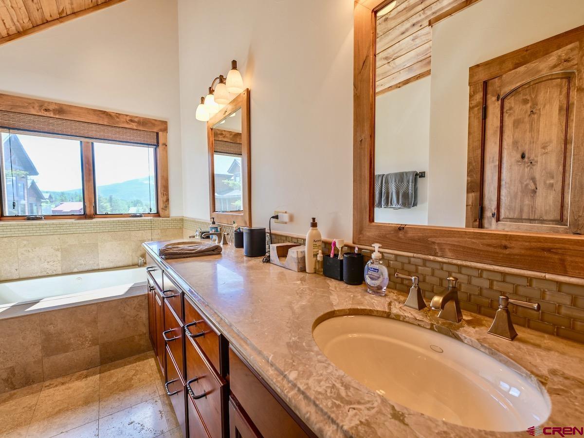 930 Gothic Road Crested Butte, CO 81225 - Photo 19 of 35 a bathroom with a granite countertop sink and a large mirror