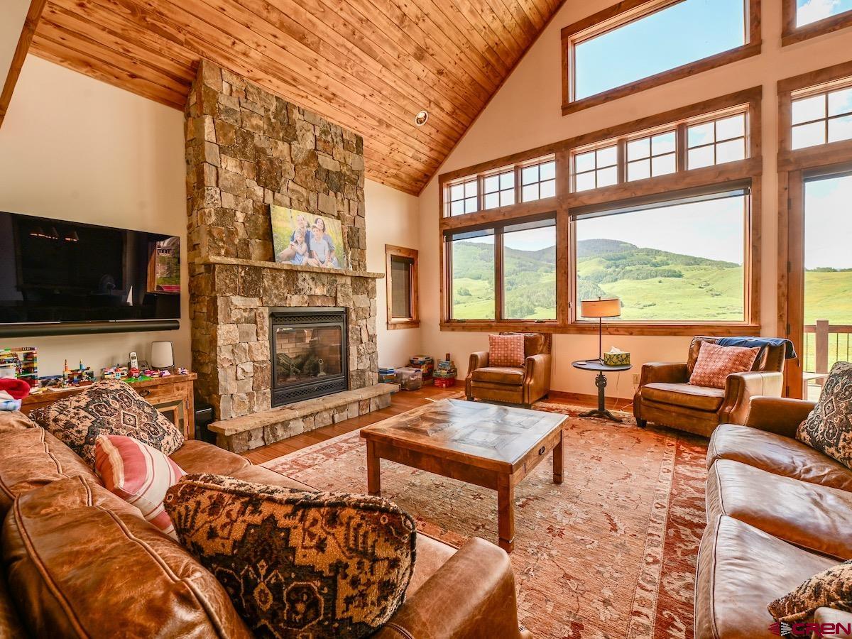 930 Gothic Road Crested Butte, CO 81225 - Photo 4 of 35 a living room with furniture a flat screen tv and a fireplace