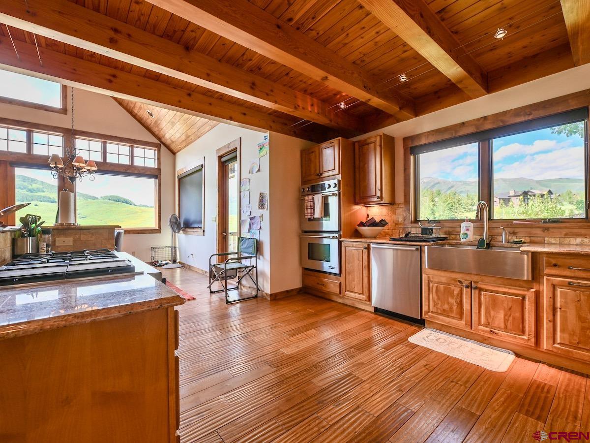 930 Gothic Road Crested Butte, CO 81225 - Photo 9 of 35 a open kitchen with stainless steel appliances granite countertop a stove a sink and a refrigerator