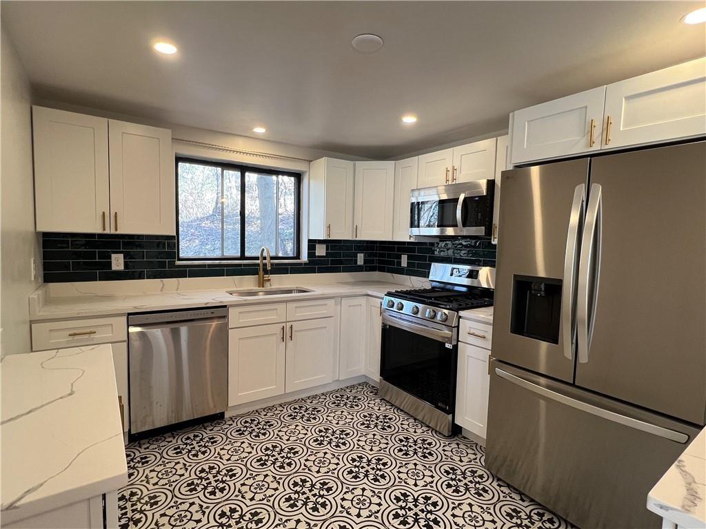 658 Fort Couch Road Pittsburgh, PA 15241 - Photo 5 of 17 a kitchen with granite countertop a refrigerator stove and microwave