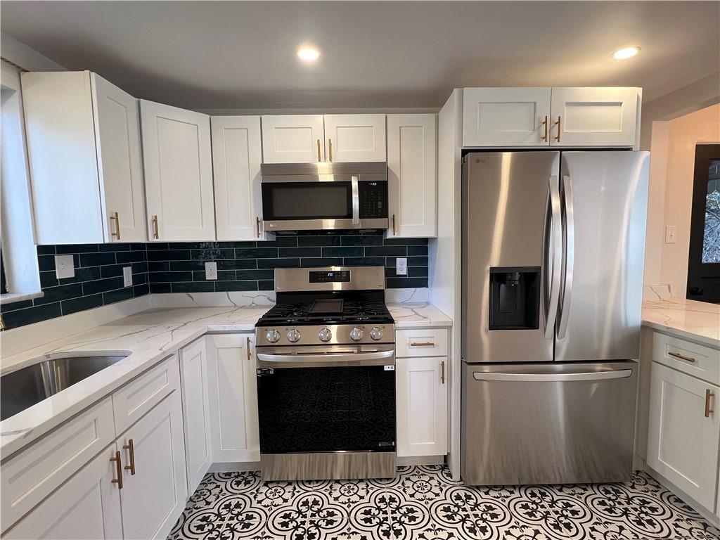 658 Fort Couch Road Pittsburgh, PA 15241 - Photo 6 of 17 a kitchen with a refrigerator stove and white cabinets