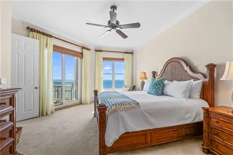 a bedroom with a bed a ceiling fan and a large window