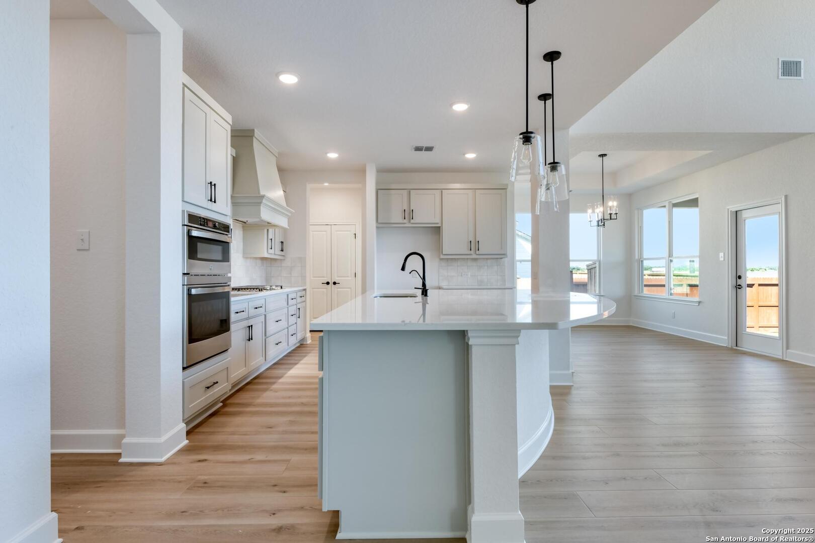 178 Annette Drive Castroville, TX 78009 - Photo 13 of 43 a large kitchen with stainless steel appliances a large counter top a stove and a wooden floors