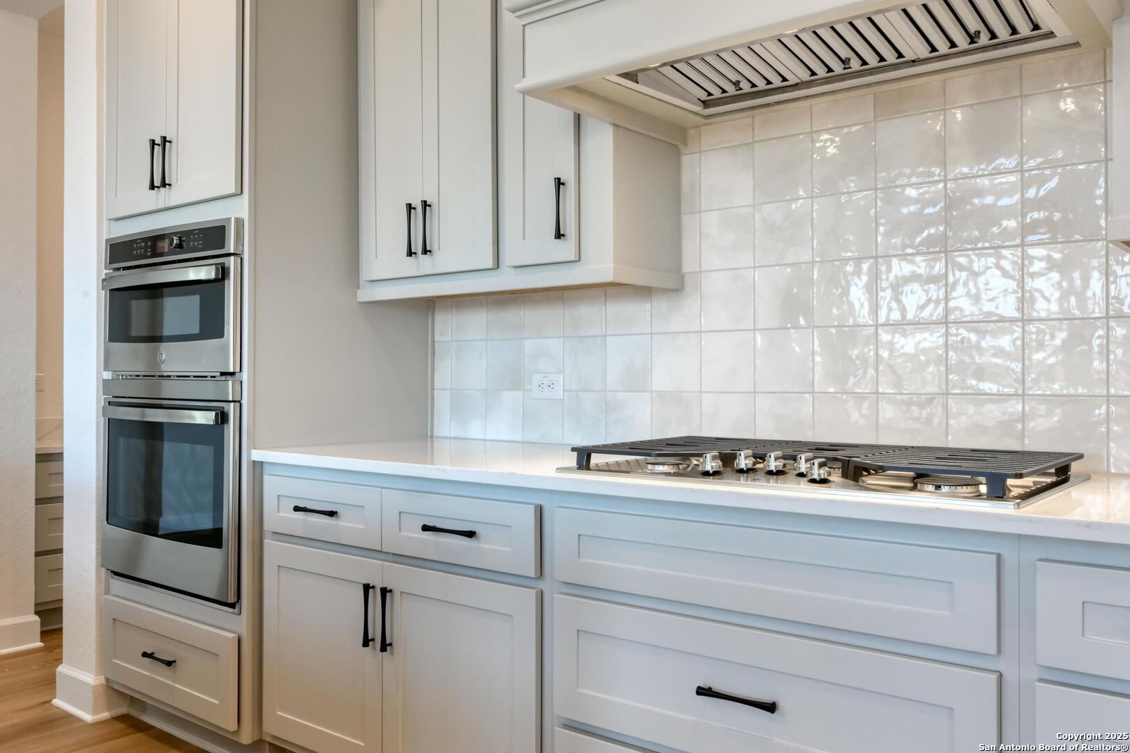 178 Annette Drive Castroville, TX 78009 - Photo 16 of 43 a kitchen with white cabinets and appliances