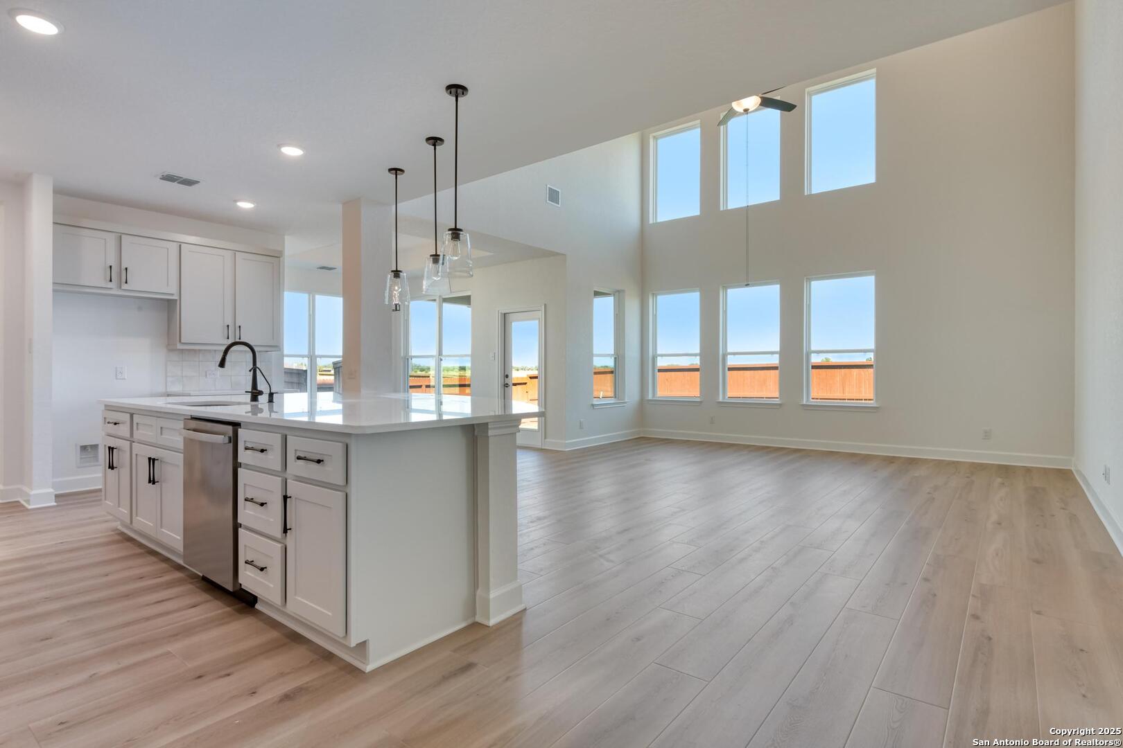 178 Annette Drive Castroville, TX 78009 - Photo 17 of 43 a kitchen with stainless steel appliances granite countertop a refrigerator a sink dishwasher a stove and white countertops with wooden floor