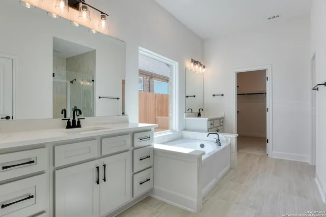 a bathroom with a bathtub a sink and mirror