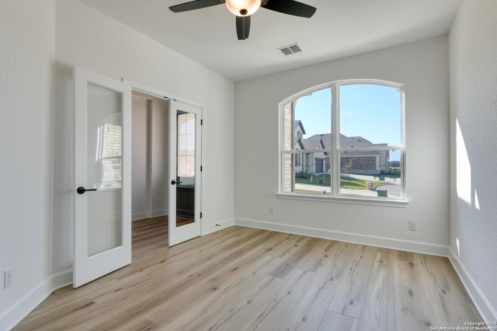 178 Annette Drive Castroville, TX 78009 - Photo 7 of 43 wooden floor in an empty room with a window