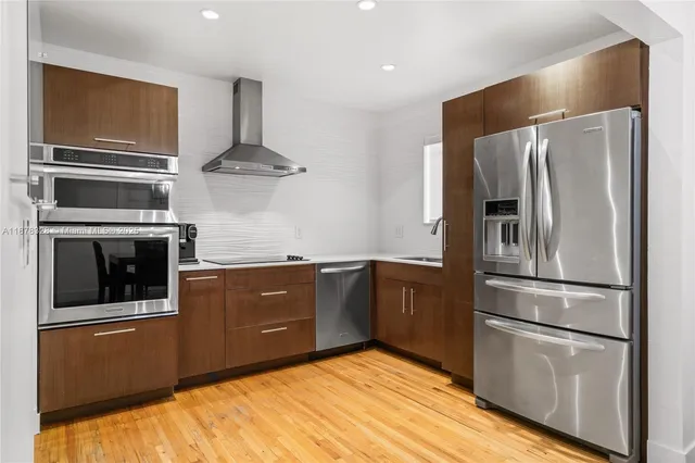 a kitchen with stainless steel appliances granite countertop a refrigerator and a stove top oven