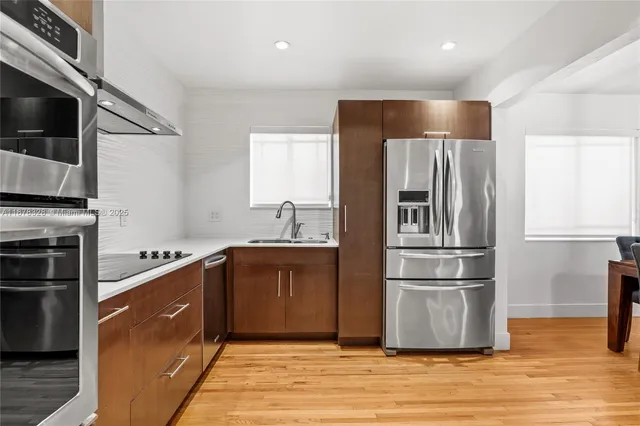 a kitchen with stainless steel appliances granite countertop a refrigerator and a sink