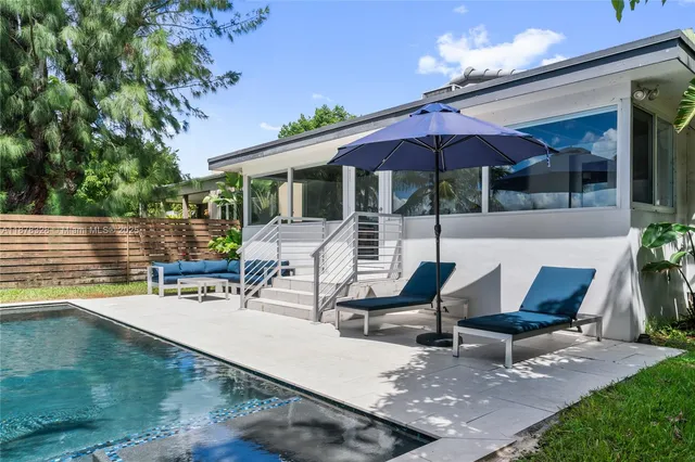a view of a patio with a table and chairs under an umbrella