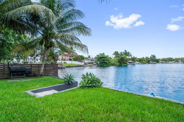 a view of a lake with a big yard and palm trees