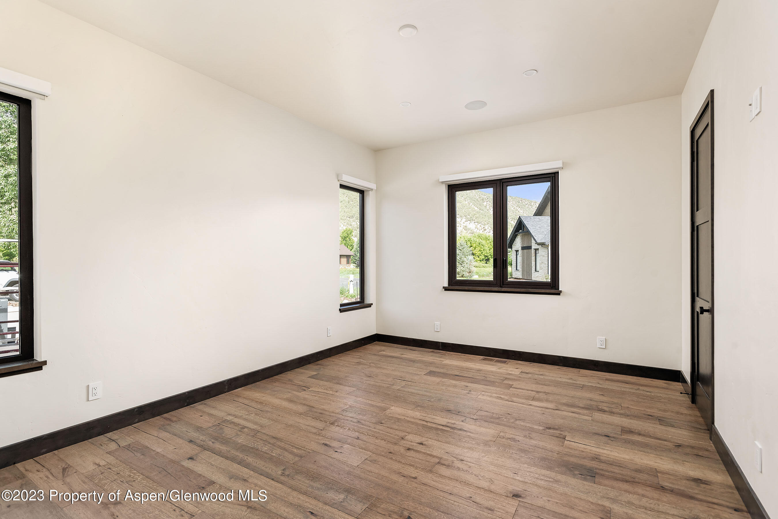 151 Sundance Trail Carbondale, CO 81623 - Photo 9 of 22 an empty room with wooden floor and windows